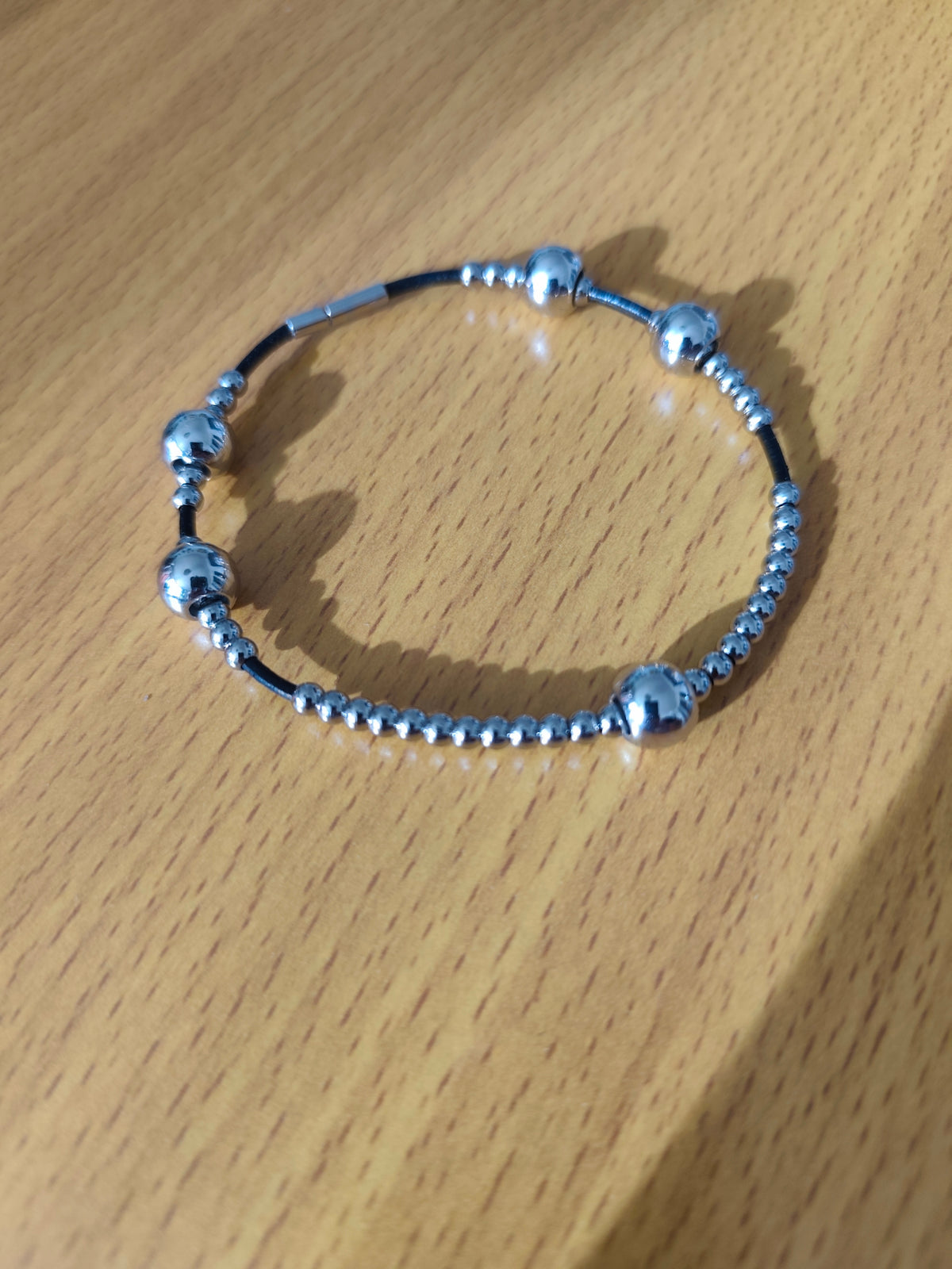 Bracelet perles métalliques sur lien en cuir