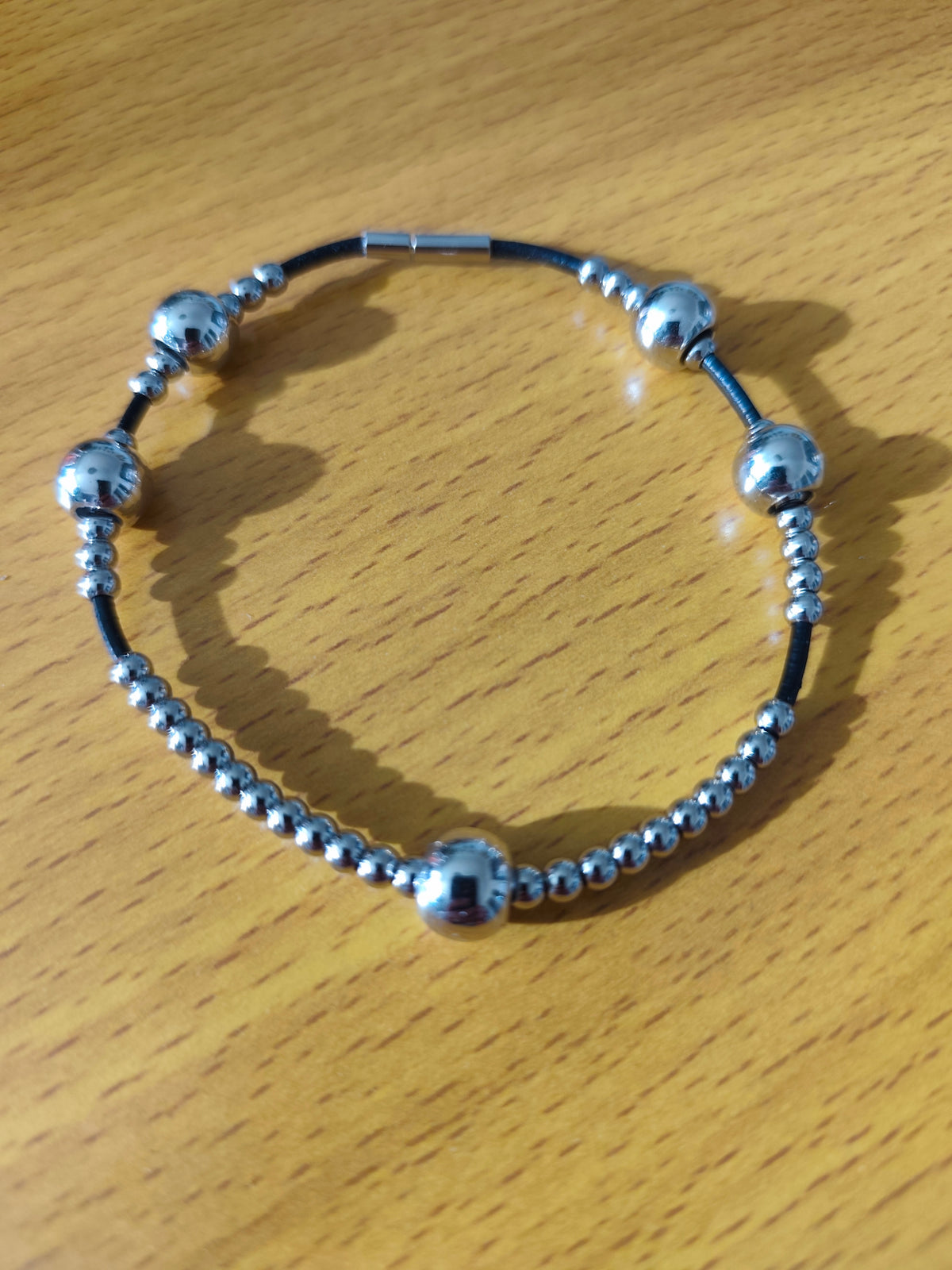 Bracelet perles métalliques sur lien en cuir